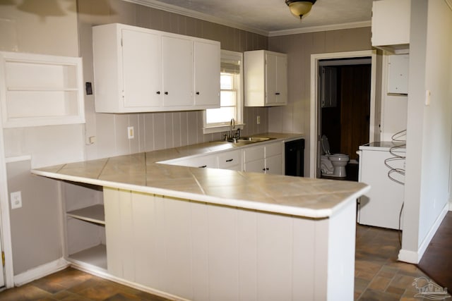 kitchen with white cabinets, kitchen peninsula, sink, and washer / clothes dryer