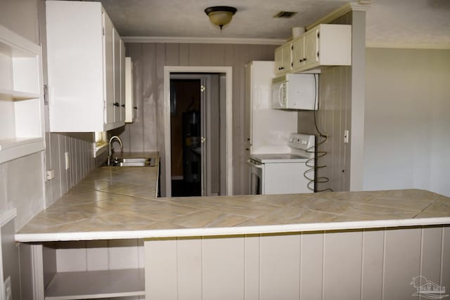 kitchen with tile countertops, sink, white cabinets, and white appliances