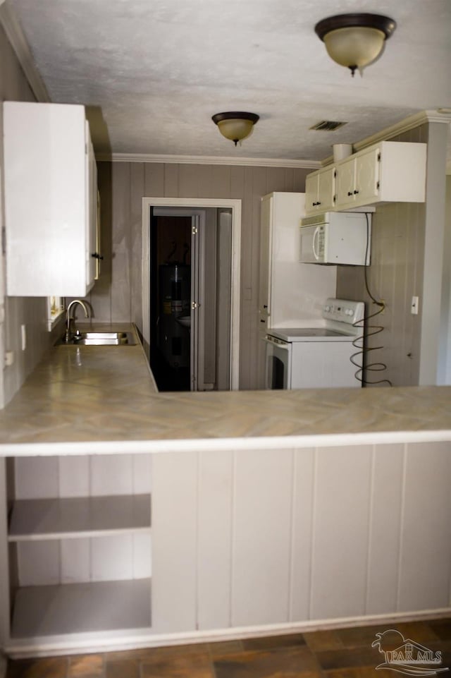 kitchen featuring white cabinetry, crown molding, white appliances, and kitchen peninsula