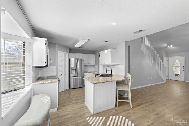 kitchen featuring pendant lighting, white cabinets, appliances with stainless steel finishes, sink, and backsplash