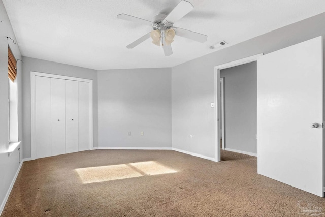 unfurnished bedroom featuring ceiling fan, a closet, and carpet floors