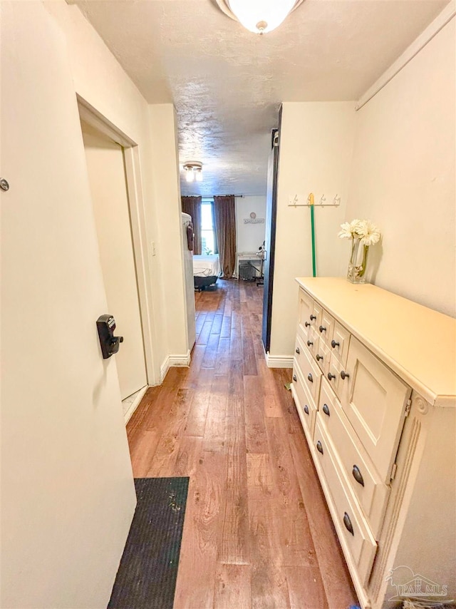 corridor with light hardwood / wood-style floors