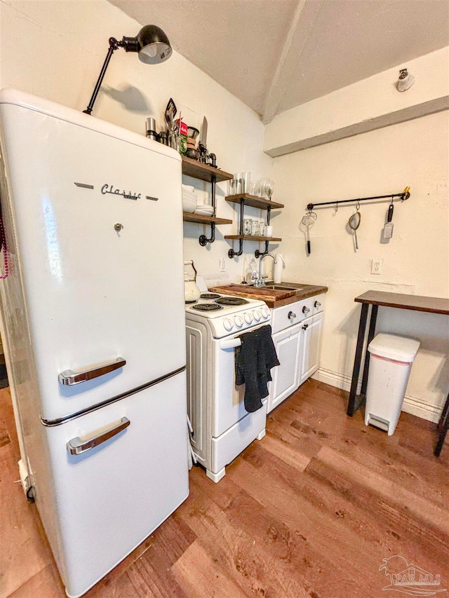 kitchen with light wood-type flooring, white appliances, white cabinetry, and sink