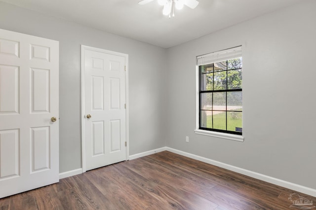 unfurnished room featuring ceiling fan and dark wood-type flooring