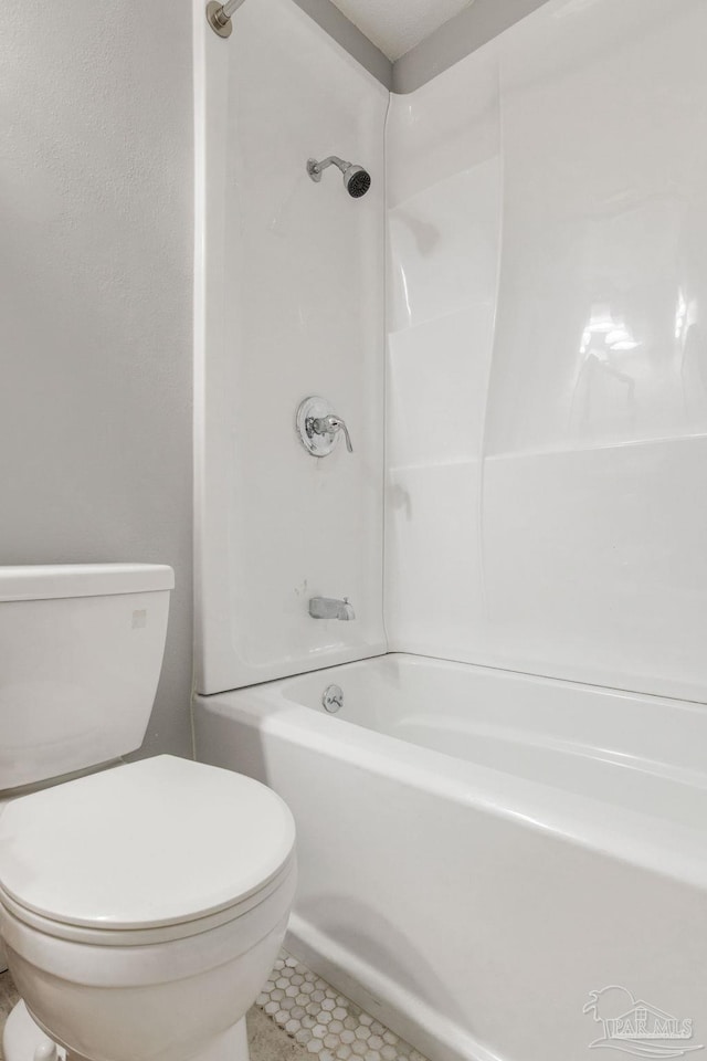 bathroom featuring bathing tub / shower combination, tile patterned floors, and toilet