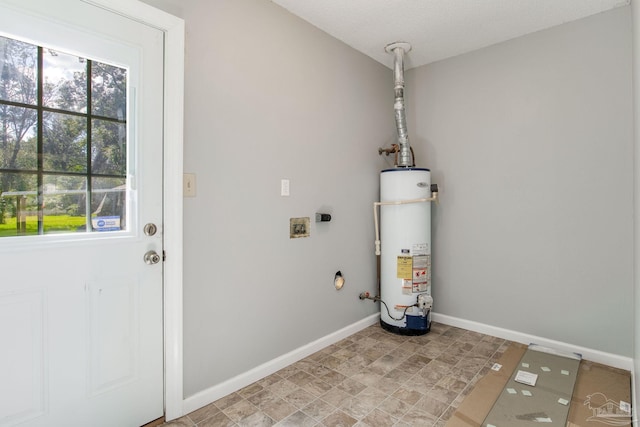 clothes washing area with washer hookup, a textured ceiling, and gas water heater