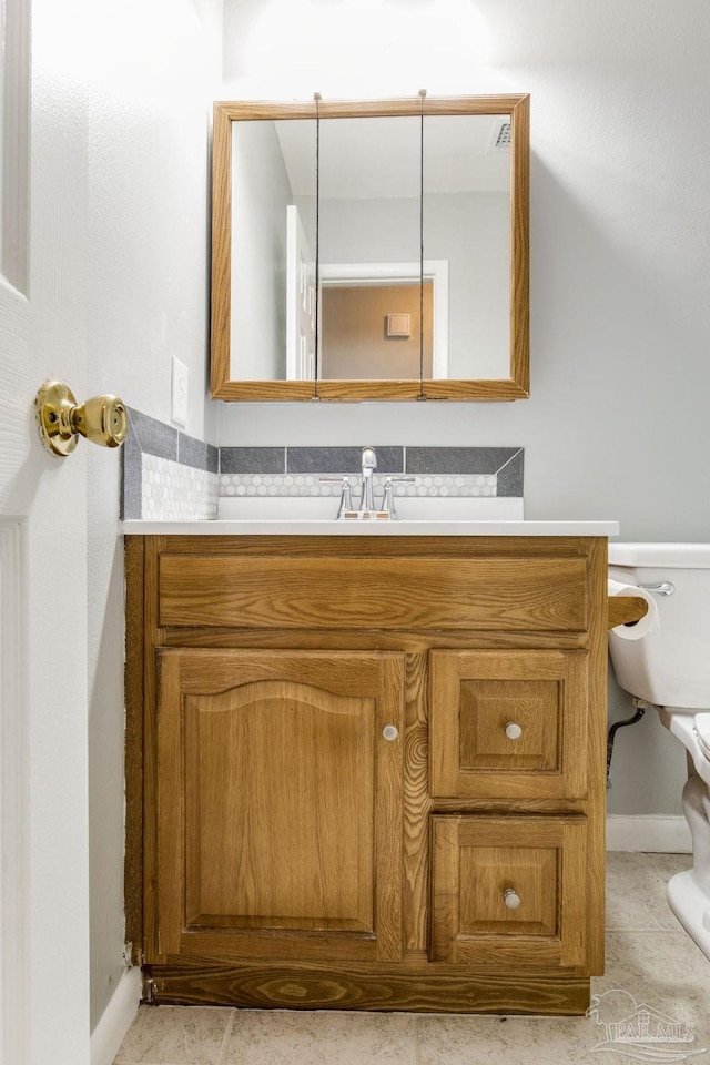 bathroom featuring tile patterned floors, vanity, and toilet