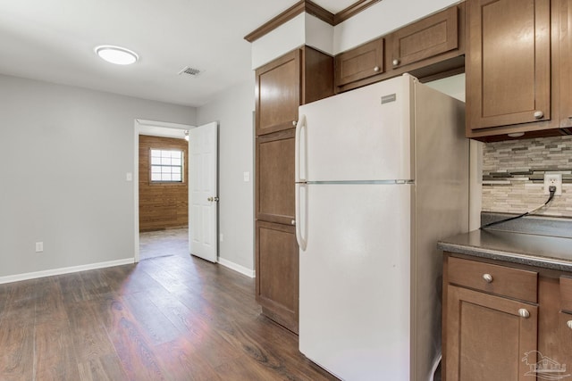 kitchen featuring white refrigerator, tasteful backsplash, and dark hardwood / wood-style flooring