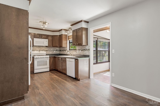 kitchen featuring white appliances, ornamental molding, dark hardwood / wood-style floors, and tasteful backsplash