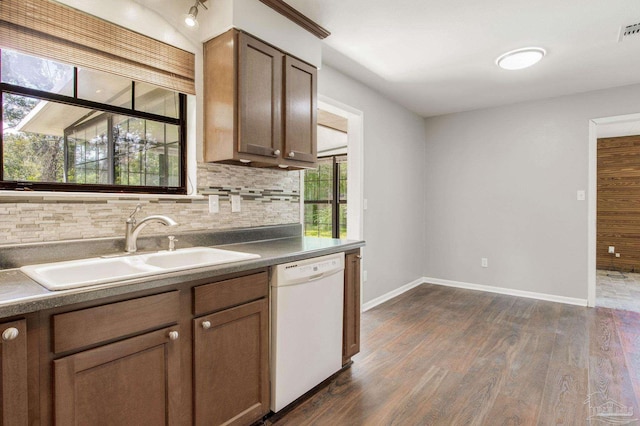 kitchen featuring dark hardwood / wood-style floors, dishwasher, sink, and tasteful backsplash