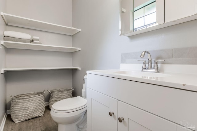 bathroom featuring wood-type flooring, vanity, and toilet