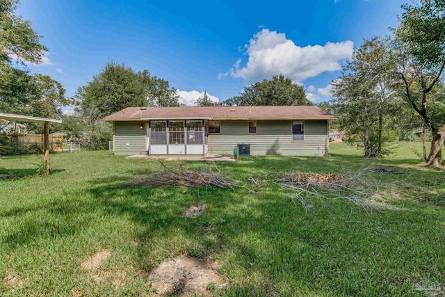 rear view of property featuring a sunroom and a yard