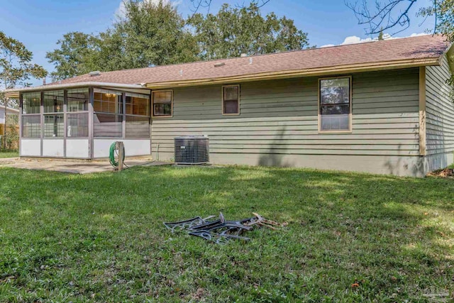 rear view of house featuring a sunroom, a yard, and central AC