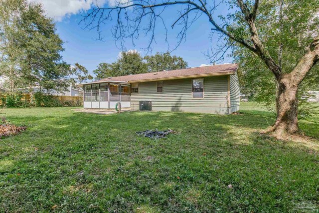 rear view of property with a yard, a sunroom, and central air condition unit