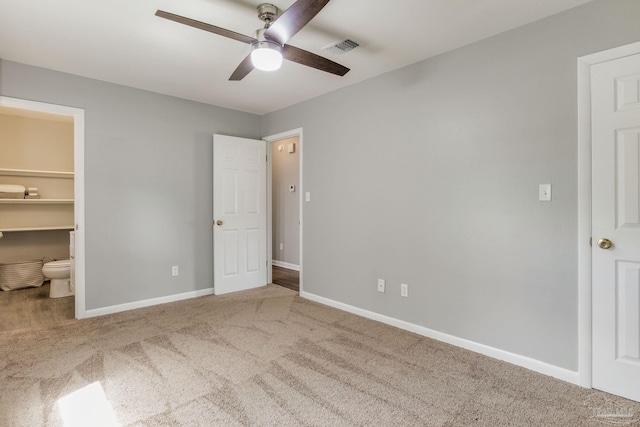 unfurnished bedroom with a spacious closet, a closet, carpet, and ceiling fan