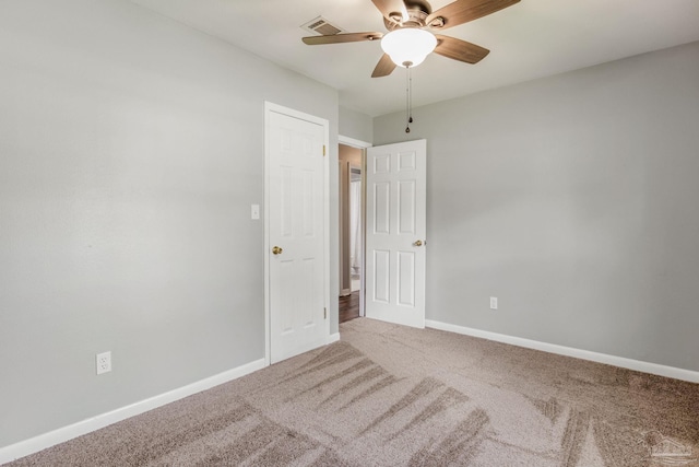 carpeted spare room with ceiling fan