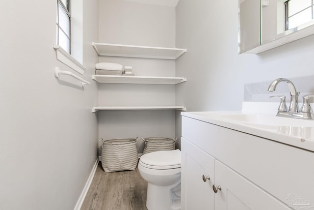 bathroom with hardwood / wood-style flooring, vanity, and toilet