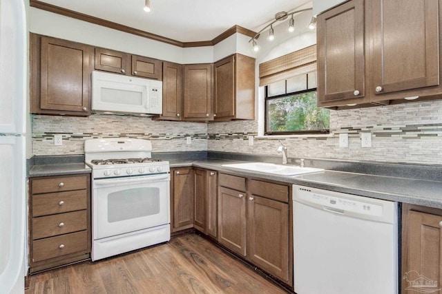 kitchen with sink, white appliances, backsplash, dark hardwood / wood-style flooring, and ornamental molding