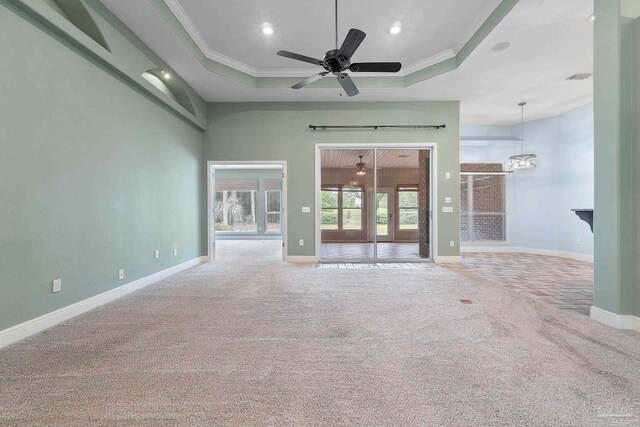 7008 Turnberry Cir, Navarre, FL 32566 - carpeted spare room with crown molding, baseboards, a raised ceiling, and ceiling fan with notable chandelier