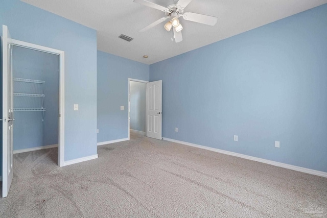 7008 Turnberry Cir, Navarre, FL 32566 - unfurnished bedroom featuring a closet, ceiling fan, a walk in closet, visible vents, and carpet