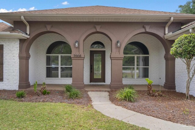 7008 Turnberry Cir, Navarre, FL 32566 - entrance to property with a yard, a shingled roof, and brick siding