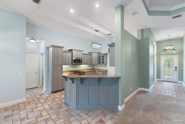 7008 Turnberry Cir, Navarre, FL 32566 - kitchen with gray cabinets, light stone countertops, stainless steel microwave, a breakfast bar area, and a peninsula
