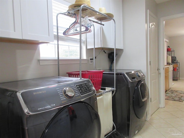 laundry area with cabinets, washing machine and dryer, and light tile patterned floors