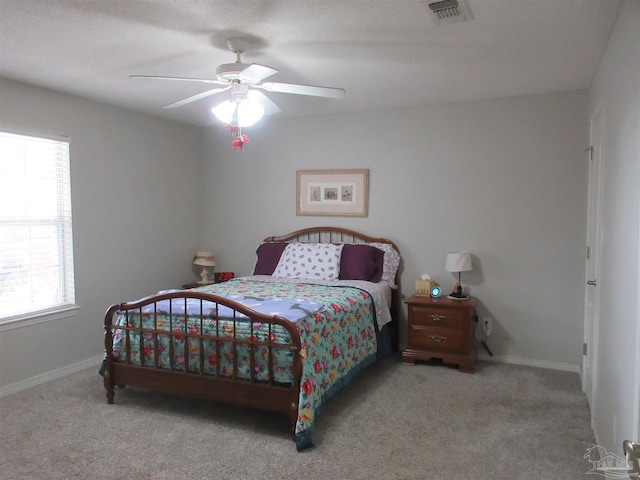 carpeted bedroom with ceiling fan and multiple windows