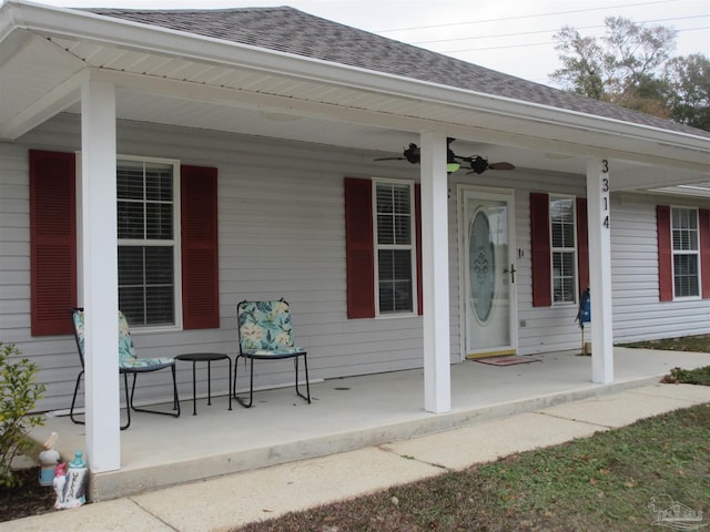 view of exterior entry with a porch and ceiling fan