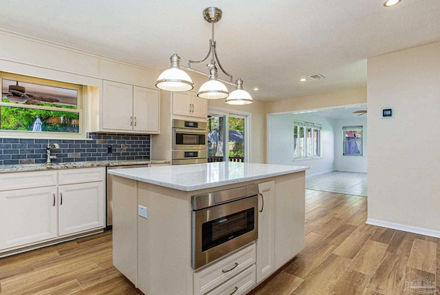 kitchen featuring a kitchen island, white cabinetry, and hanging light fixtures