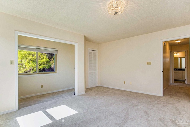 unfurnished bedroom featuring light colored carpet and a textured ceiling