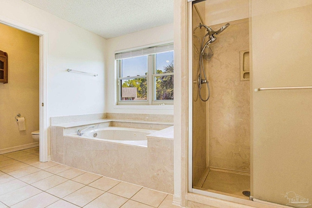 bathroom featuring toilet, tile patterned floors, separate shower and tub, and a textured ceiling