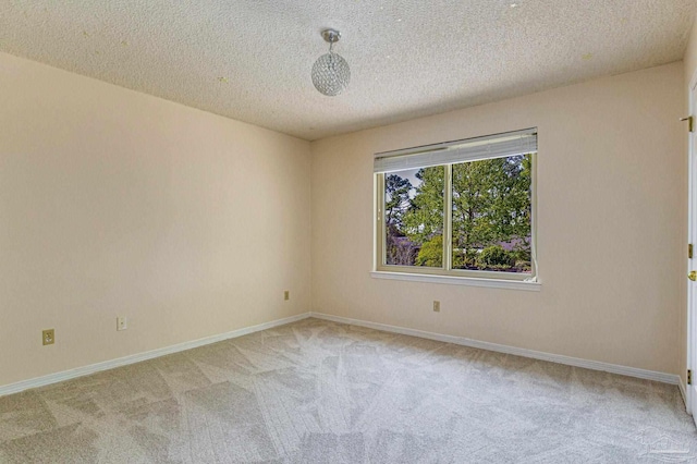 carpeted spare room with a textured ceiling