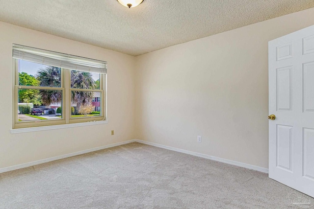 carpeted spare room with a textured ceiling