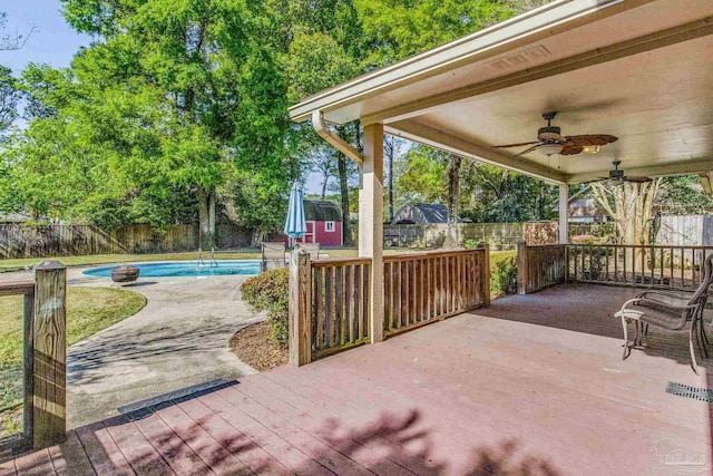 view of patio with a pool side deck, ceiling fan, and a storage unit