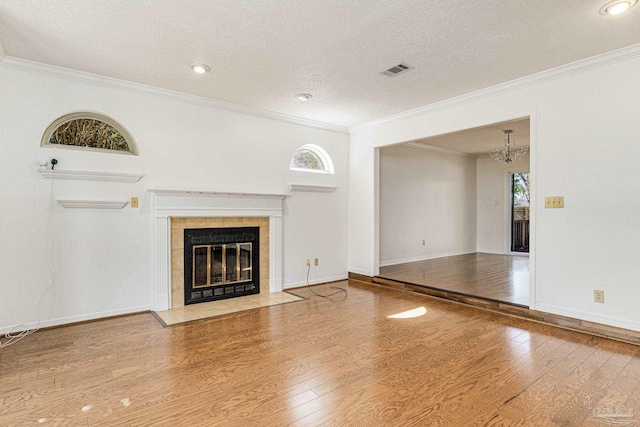 unfurnished living room featuring a fireplace, plenty of natural light, and crown molding