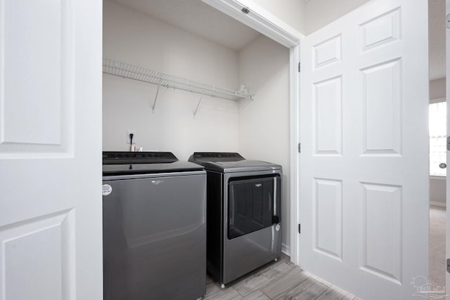 laundry area featuring laundry area, washer and clothes dryer, and light wood-style flooring