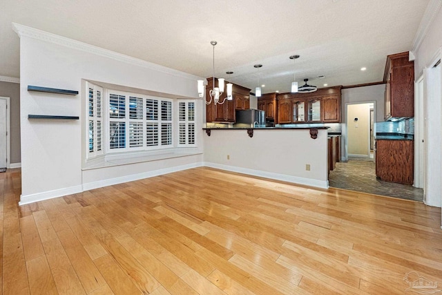 kitchen with stainless steel refrigerator, hanging light fixtures, ornamental molding, kitchen peninsula, and light wood-type flooring