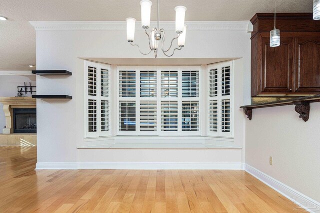 unfurnished dining area with light hardwood / wood-style flooring, crown molding, and an inviting chandelier