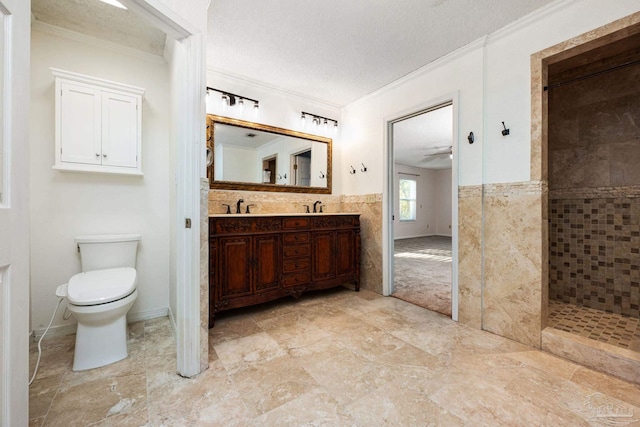 bathroom featuring vanity, crown molding, toilet, a textured ceiling, and tiled shower