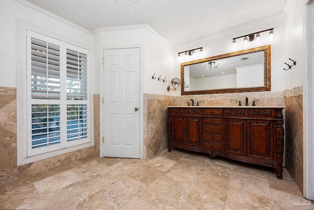 bathroom featuring a textured ceiling, crown molding, vanity, and tile walls