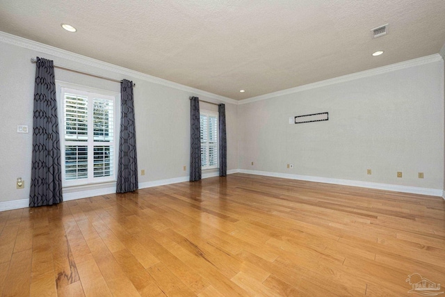 spare room featuring a textured ceiling, light hardwood / wood-style flooring, and ornamental molding