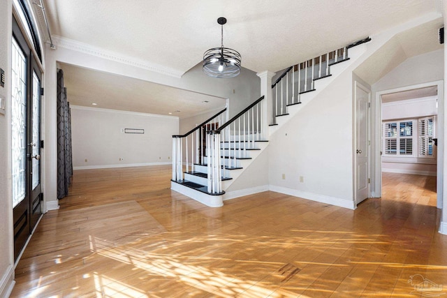 entryway featuring a chandelier, a healthy amount of sunlight, and ornamental molding