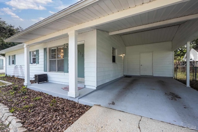 view of home's exterior with covered porch and a carport