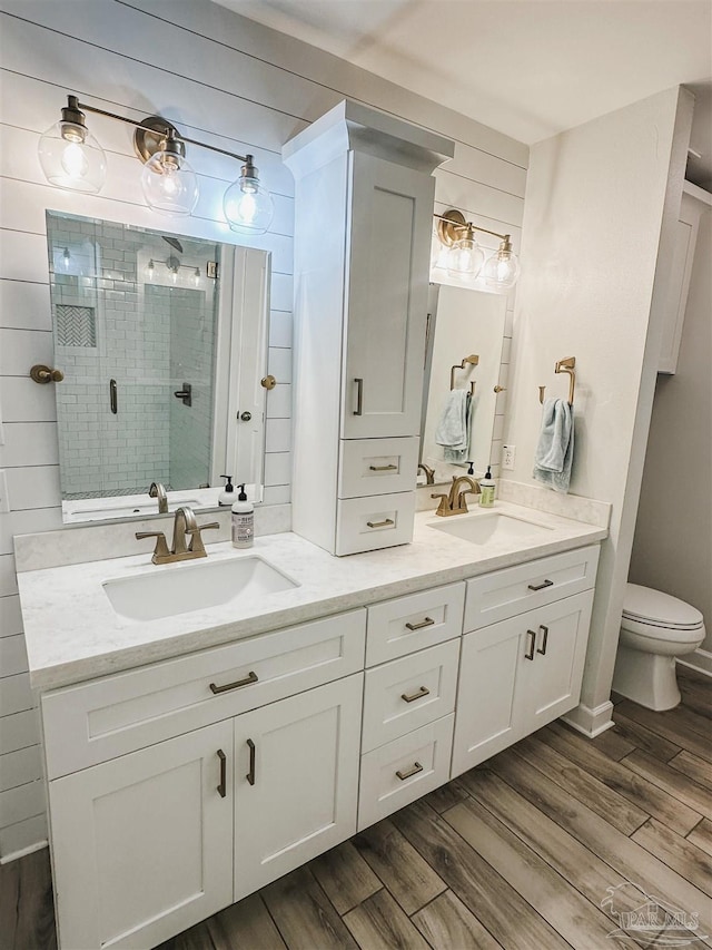 full bath with a stall shower, a sink, and wood finished floors