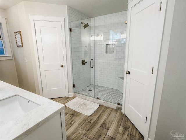 bathroom featuring a stall shower, wood finished floors, and vanity