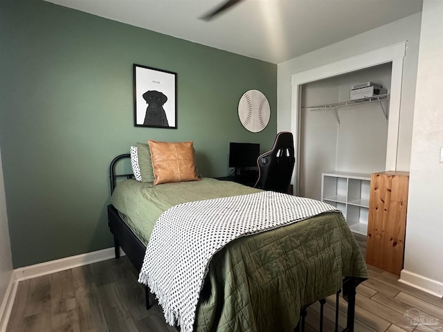 bedroom with a closet, baseboards, and wood finished floors