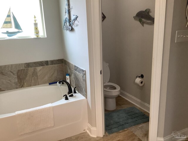 bathroom with tile patterned flooring, a bath, and toilet