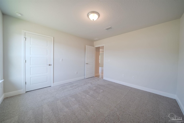 unfurnished bedroom with a closet, carpet floors, and a textured ceiling