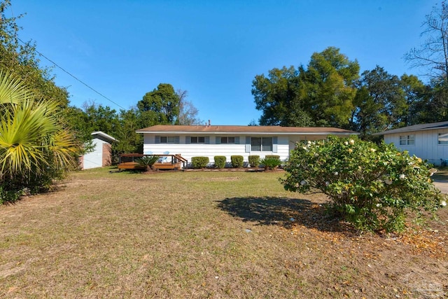 single story home featuring a storage shed, a deck, and a front lawn